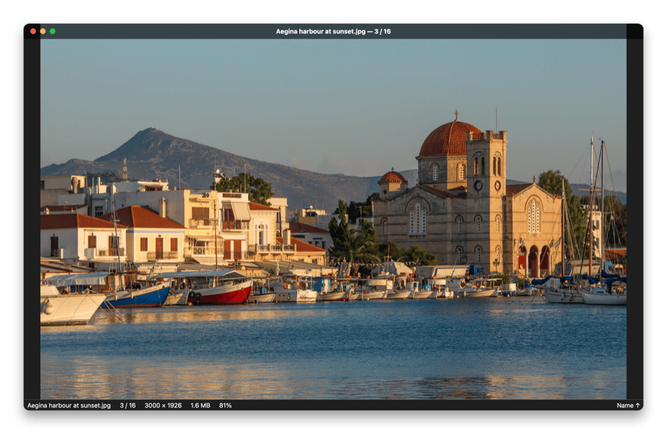 Lumaflip window in dark mode showing a photo of Aegina harbour at sunset